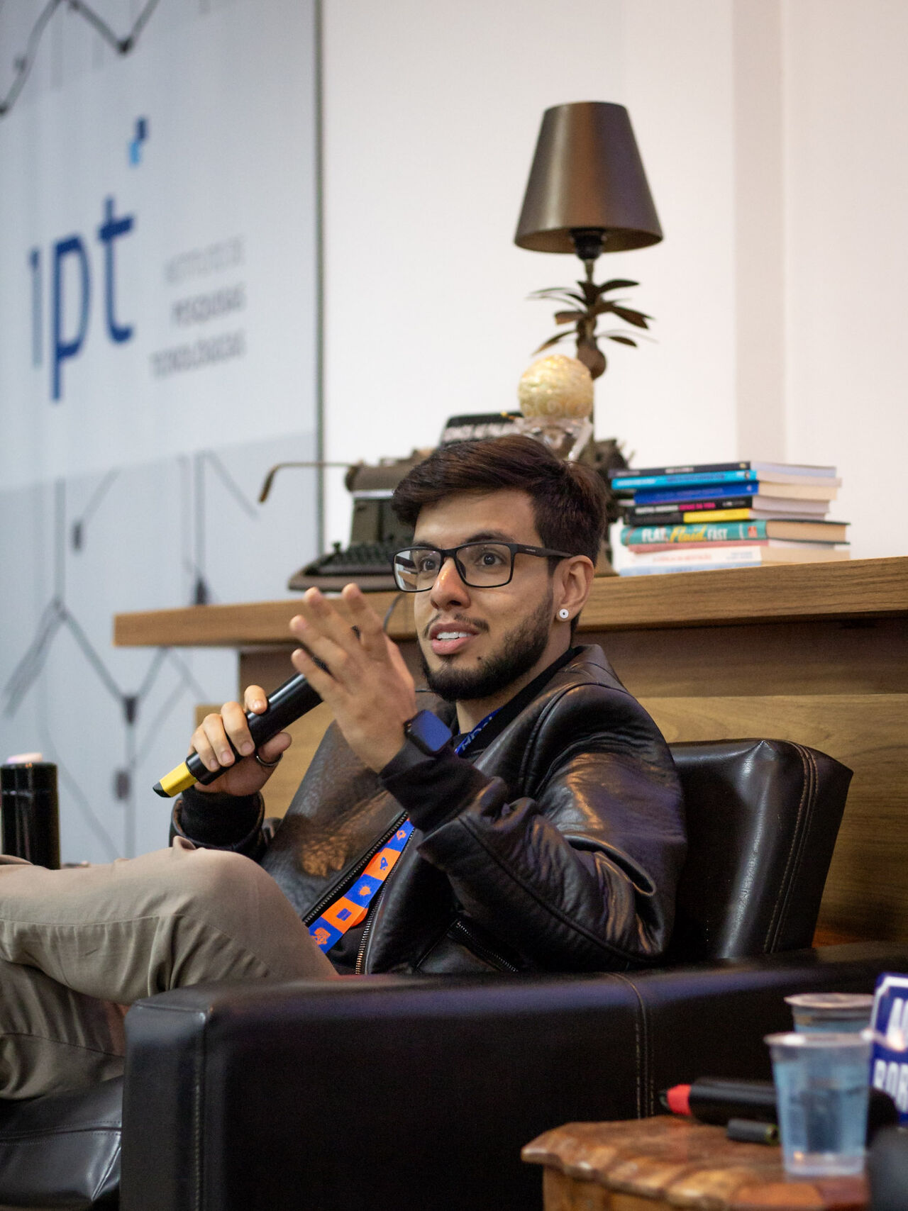 Caio Moreno com microfone na mão durante um painel no IPT.