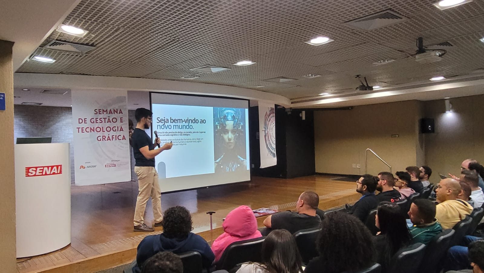 Caio Moreno em uma palestra, diante do slide Seja bem-vindo ao novo mundo
